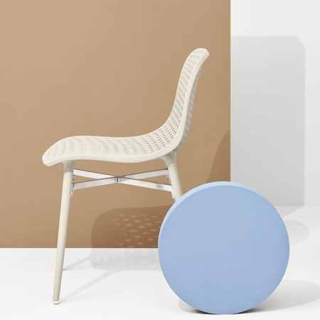 Chaise design ajourée en plastique beige avec pieds assortis, style moderne et léger de côté
