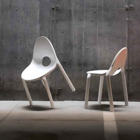 Chaises Drop blanches dans un espace brut style industriel, empilables et légères