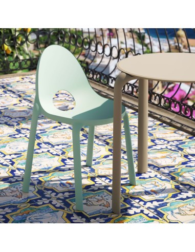 Chaise Drop vert clair sur balcon fleuri, avec carrelage décoratif méditerranéen