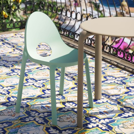 Chaise Drop vert clair sur balcon fleuri, avec carrelage décoratif méditerranéen