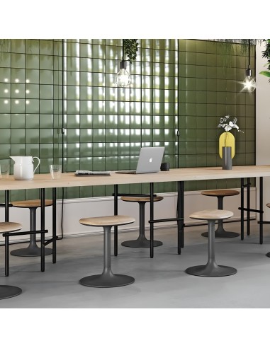 Tabourets Flink Low en bois clair autour d’une grande table partagée dans un espace de travail ou de restauration convivial
