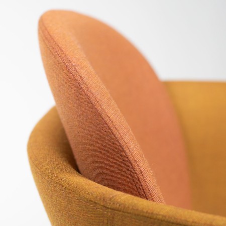 Gros plan sur le dossier rembourré orange du fauteuil Peb Low Back en tissu