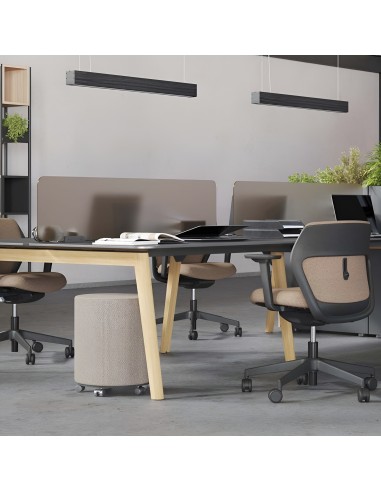 Espace de coworking avec bureaux partagés noirs et chaises ergonomiques brunes à Zürich.