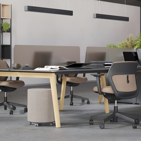 Espace de coworking avec bureaux partagés noirs et chaises ergonomiques brunes à Zürich.