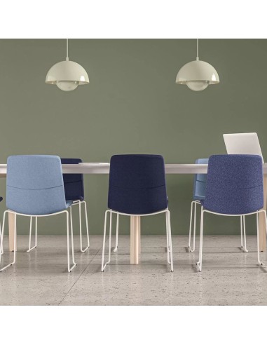 Table de réunion blanche avec piétement bois clair et chaises bleues claires et foncées