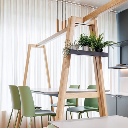 Tabourets Polytone L autour d’une table haute dans un espace détente