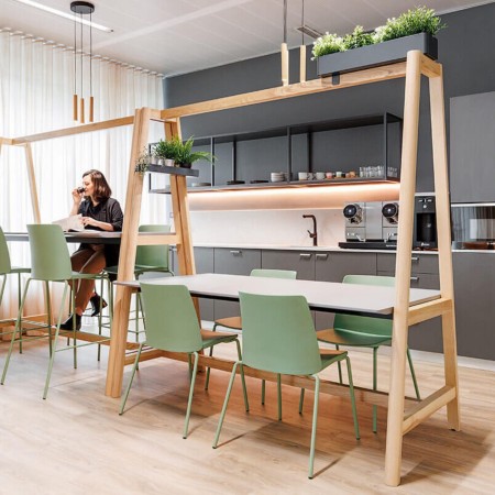 Chaise Polytone L verte autour d'une table haute avec structure bois – ambiance coworking