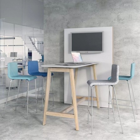 Tabourets de bar Moon autour d’une table haute en bois clair dans un espace détente moderne