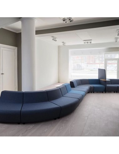 Système modulaire en forme de S avec canapés bleus, un écran et tablette intégrée