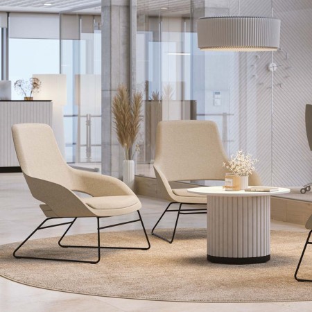 Fauteuil lounge beige en tissu dans un espace lumineux avec table basse en bois