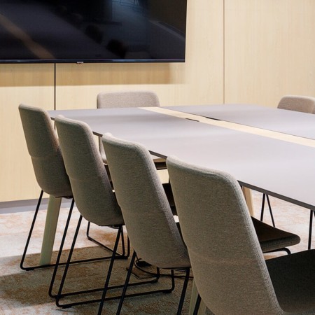 Chaises TWIST&SIT tapissées avec piètement luge noir autour d’une table de réunion