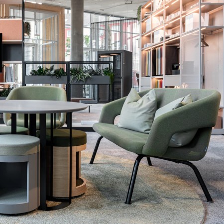 canapé TWIST&SIT vert avec coussins dans un espace lounge d’entreprise