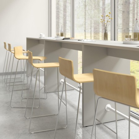 Tabourets hauts en bois Moon Wood devant table allongée et grande baie vitrée