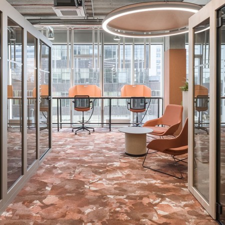 Table basse PARTHOS à côté des bureaux, open-space lumineux