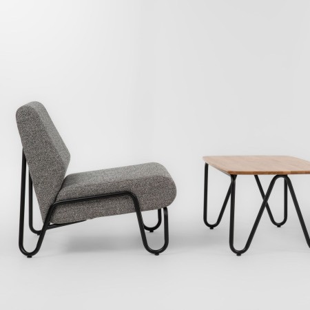 Fauteuil Clip en tissu gris, mis en situation avec table basse en bois – Clip