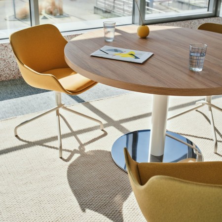 Table ronde de réunion dans pièce lumineuse et chaises design