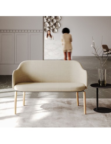 Femme assise sur un banc Flos beige dans un grand hall - Flos
