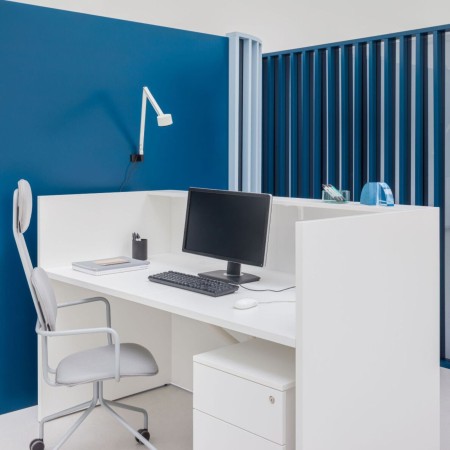 Aménagement de l'arrière du meuble de réception avec ordinateur et siège de travail