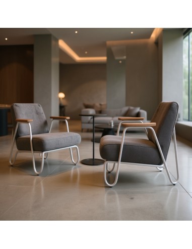 Fauteuil Clip en tissu gris avec accoudoirs bois dans hall d'accueil d'un hôtel en Suisse