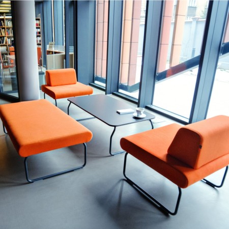 Fauteuils Legvan orange installés face à de grandes baies vitrées - Legvan