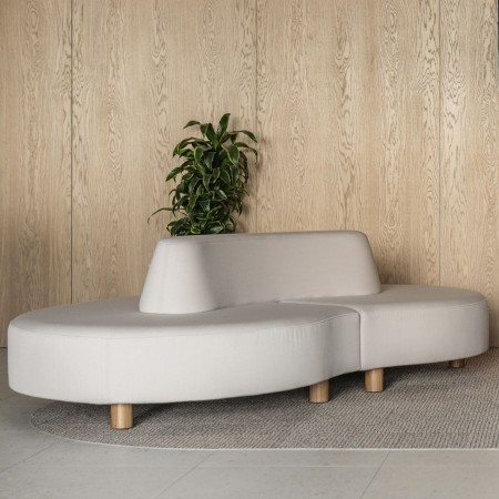 Canapé Nubi gris clair contre un mur beige - Nubi