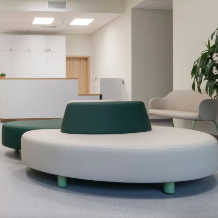 Canapé Nubi arrondi en tissu vert et beige, espace d’accueil - Nubi