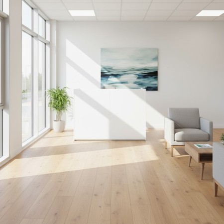 Petit meuble de réception blanc dans espace d'attente avec fauteuil et table basse