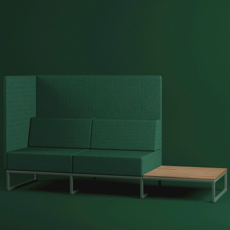 Un canapé modulaire vert foncé avec dossier haut et tablette en bois intégrée sur le côté droit, apportant une touche chaleureus