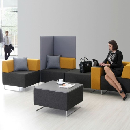 Zone collaborative avec modules d’assise colorés formant un espace flexible. - Quadra