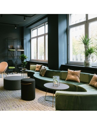 Vue d’ensemble d’un aménagement vert et beige dans un espace lumineux. - Quadra