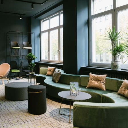 Vue d’ensemble d’un aménagement vert et beige dans un espace lumineux. - Quadra