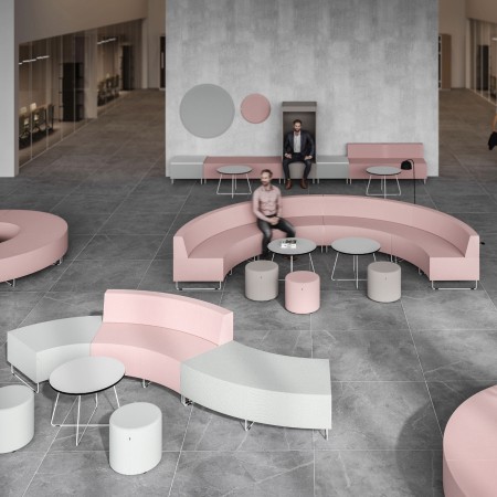 Espace lounge avec banquettes roses et beiges autour de tables basses. - Quadra