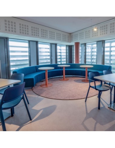 Espace ouvert avec banquettes vertes et fauteuils bleus. - Quadra