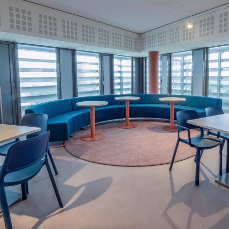 Espace ouvert avec banquettes vertes et fauteuils bleus. - Quadra