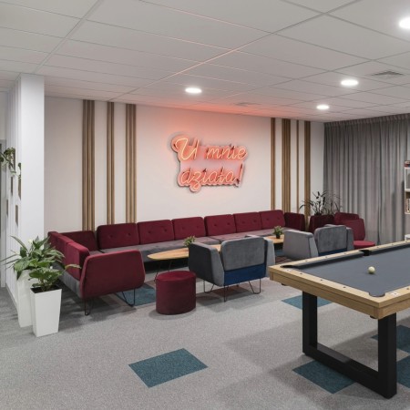 Zone détente moderne avec fauteuils rouges et ambiance chaleureuse. - U Floe