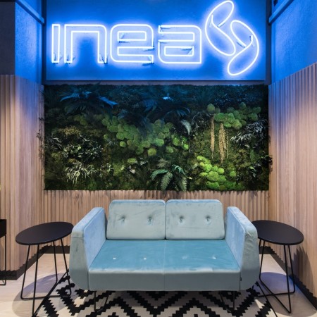 Espace d’accueil coloré avec canapé bleu clair devant un mur lumineux. - U Floe