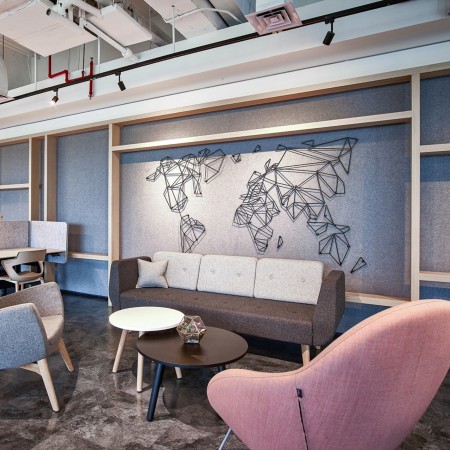 Open space lumineux avec canapés modulaires pastel et bois clair. - U Floe