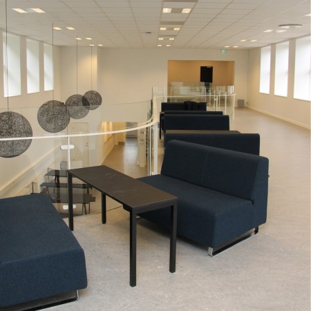 Zone lounge avec fauteuils bleus et table basse rectangulaire. - Voo Voo