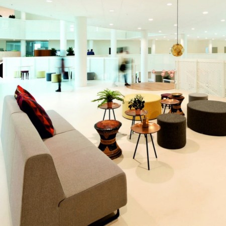 Salon d’entreprise lumineux avec canapés colorés et tables bois. - Voo Voo