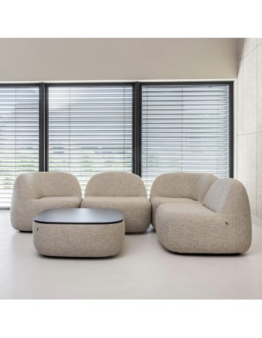 Fauteuils et poufs bouclés beiges près d’une grande baie vitrée. - Jelly