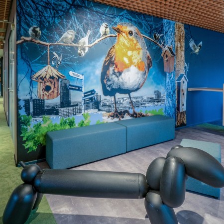 Espace ludique avec banquette Long Cube verte devant une fresque colorée. - Long Cube