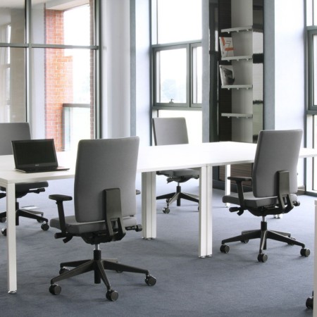 Postes de travail équipés de fauteuils Mate MT 102 gris dans un open space lumineux