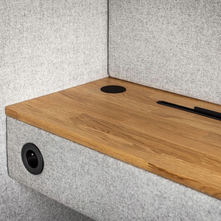 Tablette en bois clair avec prise intégrée dans la cabine acoustique Quadra. - Quadra