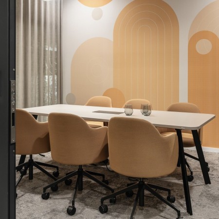 Salle de réunion beige avec chaises confortables sur roulettes et accoudoirs Flos