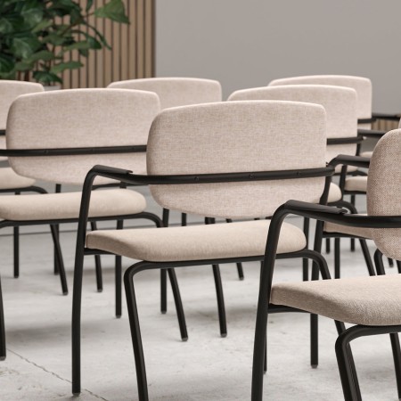 Chaises beiges, piètements noirs dans salle de conférence