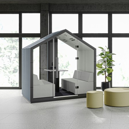 Cabine Treehouse grise installée près d’une baie vitrée avec banquettes vertes. - Treehouse