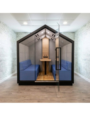 Cabine Treehouse vue intérieure avec deux assises en tissu bleu et table centrale. - Treehouse