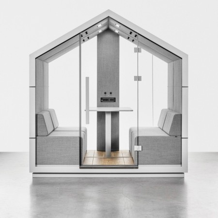 Intérieur de la cabine Treehouse en finition blanche avec banquettes et table minimaliste. - Treehouse