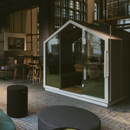Cabine Treehouse vitrée installée dans un hall spacieux et moderne. - Treehouse