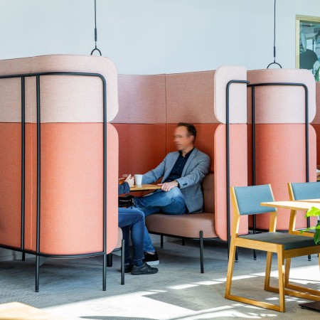 Alcôve Fora rose utilisée comme espace semi-privé pour le travail individuel dans un bureau moderne. - Fora